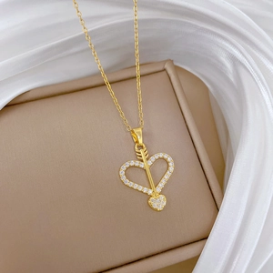 Detailed close-up of a golden cupid arrow heart pendant with shimmering crystals