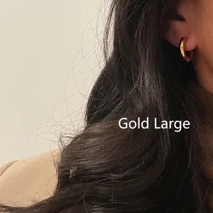 Chic 18k gold plated stainless steel large hoop earrings worn by a model in a minimal style