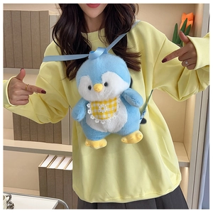 Detail of cute blue penguin plush backpack featuring a yellow plaid bib and lace trim