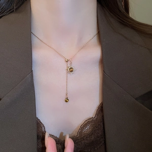 Detail of 18k gold plated sun pendant necklace featuring tiger eye stones on model