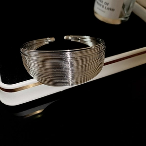 Detailed view of wide silver multi-layer woven cuff bracelet with metallic texture