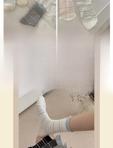 Detail of striped cotton crew socks in pastel tones with a comfortable rolled edge finish
