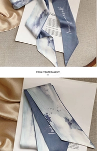 Detailed close-up of a blue mountain landscape silk scarf with love yourself lettering