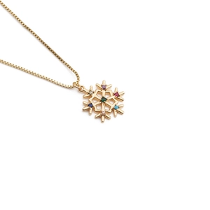Gold plated snowflake necklace with vibrant multicolor zircons on a white background