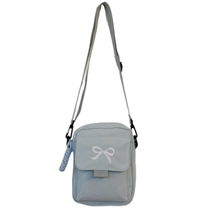Light blue canvas crossbody bag with white embroidered bow and adjustable strap