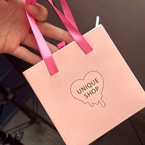Boîte cadeau bijoux rose avec poignée en soie et logo coeur pour emballage élégant