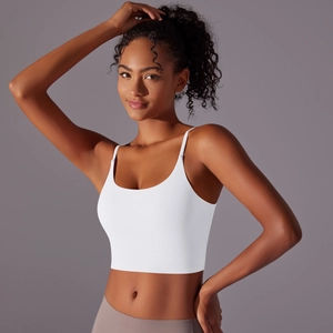 Detailed view of white cropped yoga tank top with thin straps and seamless elastic fabric