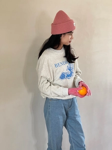 Detalle de la sudadera de algodón gris claro con estampado Bendio azul y textura de tela suave