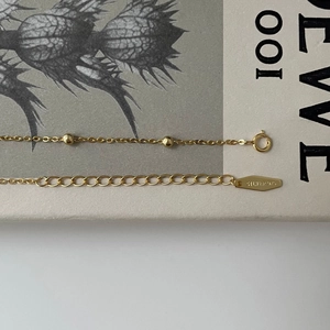 Detail of 925 sterling silver gold chain with beads, spring clasp and metal hallmark