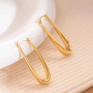 Detailed close-up of gold-plated U-shaped drop earrings with a polished metallic finish
