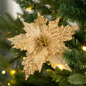 Champagne gold glitter velvet poinsettia flower ornament on a green Christmas tree