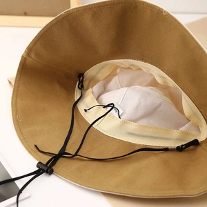 Detail of outdoor sun hat interior featuring white sweatband and adjustable windproof cord