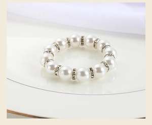 Close-up of elegant faux pearl napkin ring with crystal rhinestones on a white plate