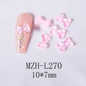Macro detail of aurora pink bow nail charms showing 10x7mm dimensions for 3D nail art designs
