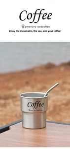 Outdoor stainless steel coffee cup with matching metal straw on a wooden table