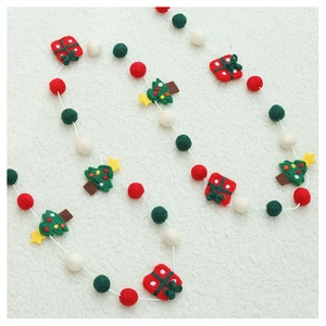 Macro shot of wool felt Christmas garland with festive tree and gift box ornaments