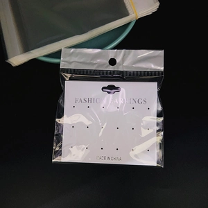 Close-up of white PVC multi-hole earring cards with clear plastic hanging bags