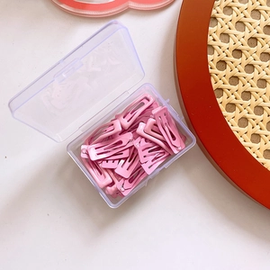 Pink metal hair clips stored in a clear Easy Day plastic storage box detail