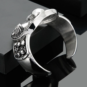 Macro shot of punk style stainless steel open cuff with detailed skull engravings