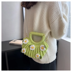 Green crochet shell bag with white daisy accents and pearl chain strap on model