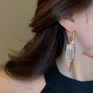 Close-up of sparkling zirconia tassel earrings with gold-tone cascading fringes