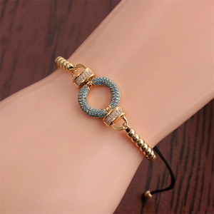 Detail of gold-plated geometric bracelet with turquoise beads and micro-pave zircons