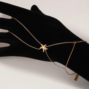 Minimalist gold starfish hand chain bracelet for women on a professional black hand model