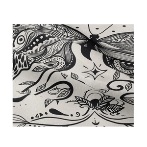 Détail macro d'une tapisserie mandala bohème montrant le tissu imprimé papillon noir et blanc