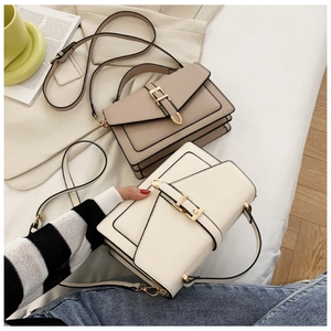Detail of minimalist faux leather handbags in beige and cream with gold metal buckles