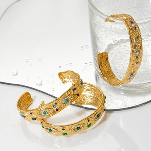 Bracciale rigido dorato aperto con trama a rilievo vintage e pietre preziose colorate