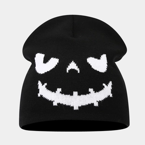 Close-up of black knitted beanie featuring white Halloween skull face jacquard texture