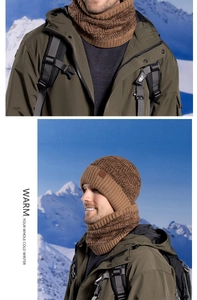 Detail of brown knitted winter hat and neck warmer set with snow mountain background