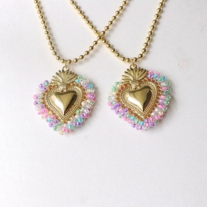 Detailed close-up of golden mirror heart pendants with vibrant multi-colored beads