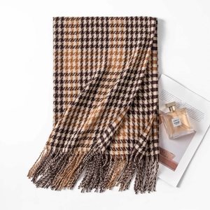 Thick houndstooth scarf in brown and beige colors with fringe on white background