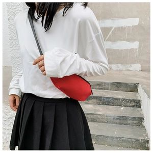 Close-up of bright red nylon chest bag for women in street style outfit