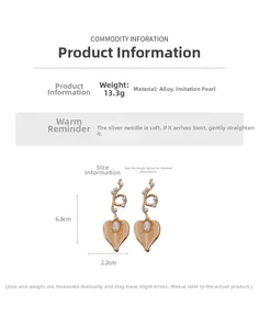 Macro shot of pearl heart earrings with 6.8cm length measurements on white background