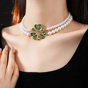 Dettaglio collana di perle a doppio filo con ciondolo a fiore in cristallo verde indosso