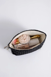 Detailed view of polka dot makeup bag showing large capacity with pearls and zipper
