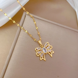 Detailed macro of gold bow pendant with sparkling marquise and baguette zircons
