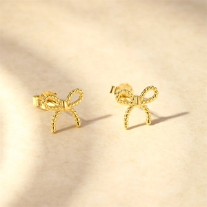 Gros plan de boucles d'oreilles nœud doré en argent S925 avec poinçon de certification
