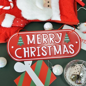 Red metal Merry Christmas oval door sign with white lettering on festive green background