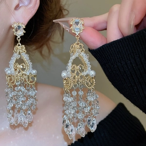 Detailed close-up of French crystal chandelier earrings with pearl tassels and gold plating