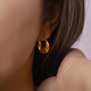 Fashionable golden twisted hoop earrings for women with irregular minimalist design