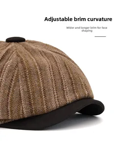 Detail of vintage herringbone newsboy cap featuring a flexible, wide black brim design