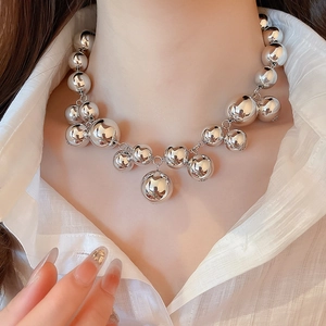 Detail of silver geometric oversized ball pendant necklace with polished mirror finish