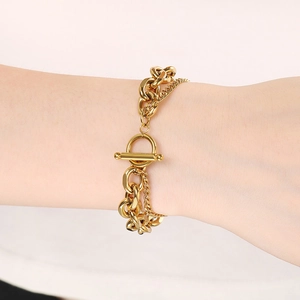 Nahaufnahme eines doppellagigen Goldkettenarmbands mit OT-Verschluss am Handgelenk