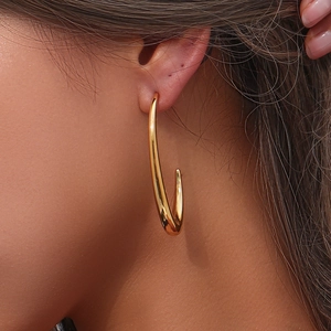 Close-up of minimalist gold-plated V-shaped hoop earring on model with polished finish