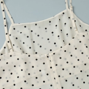 Detailed view of adjustable straps and invisible zipper on polka dot chiffon top