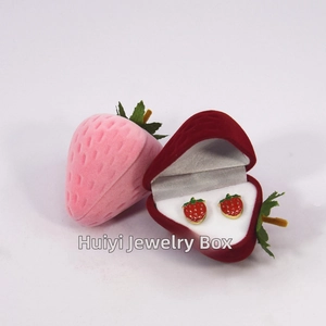 Detail view of pink and red strawberry velvet jewelry boxes with matching earrings
