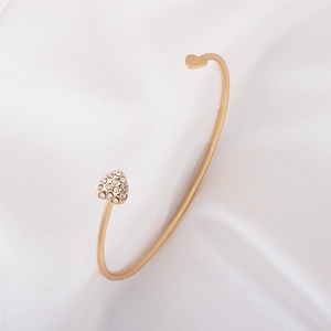 Elegant gold open heart bracelet with white crystal rhinestones on white satin fabric